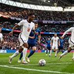 Nazionale inglese Three Lions con la maglia bianca durante una partita su campo da calcio